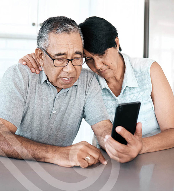 Photo of an elderly couple looking at a mobile phone together
