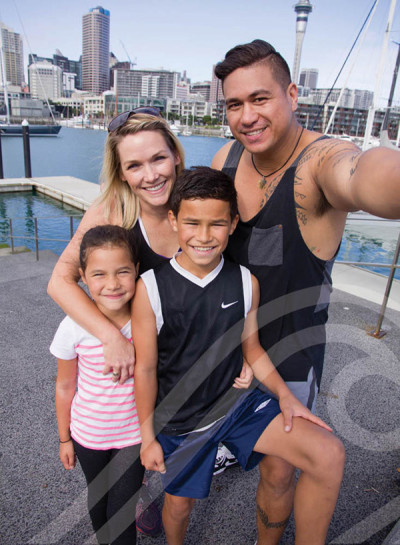 Image of a family - two adults and two children - posing together outdoors