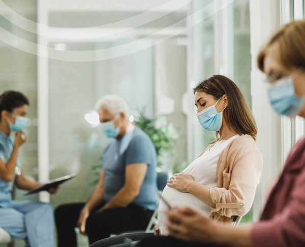 Healthcare workers in masks in waiting room.