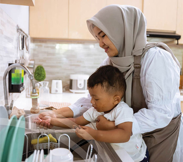 Photo of adult and child washing hands at a sink