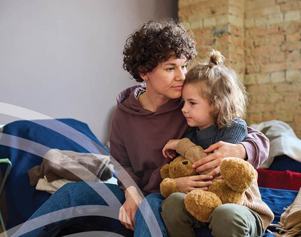Photo of a parent comforting a child on a bed