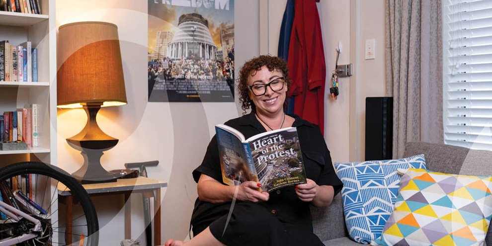 Meagan sits on her couch and reads a book.
