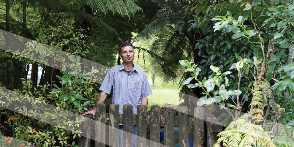 Sean Leach stands in his garden amongst native trees