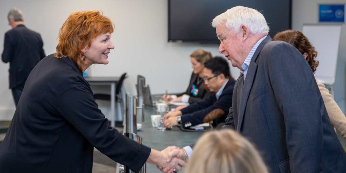 Justine Cornwall shakes hands with member of the employers and manufacturers association at a recent meeting.