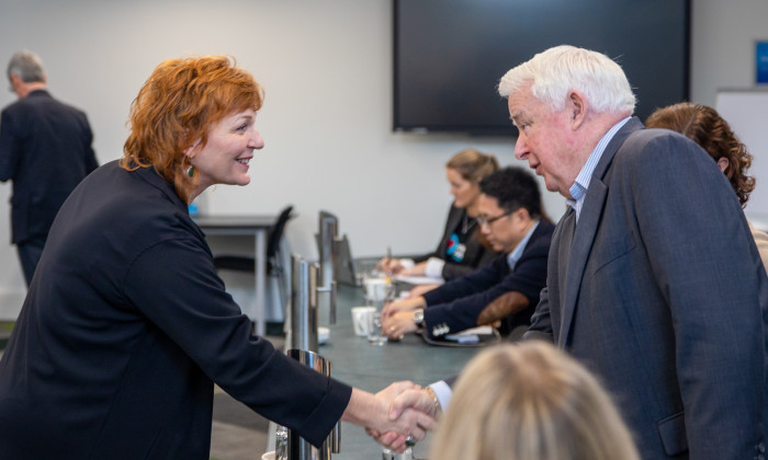 Justine Cornwall shakes hands with member of the employers and manufacturers association at a recent meeting. 